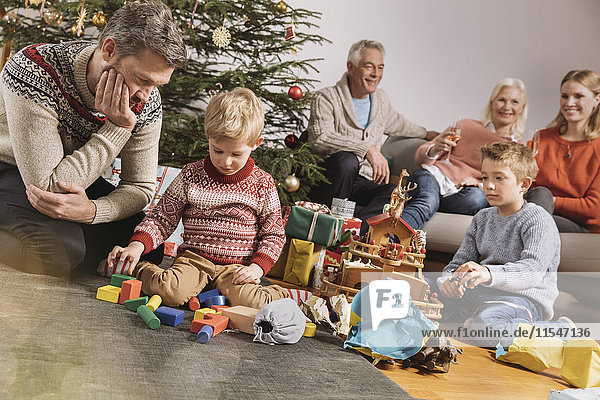 Drei Generationen Familie feiert Weihnachten  Kinder packen Geschenke aus