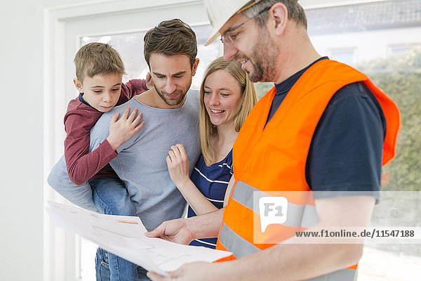 Bauarbeiter erklärt der Familie den Bauplan