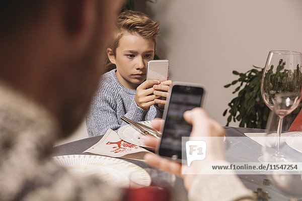 Boy playing with his smartphone after Christmas dinner