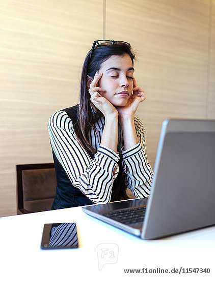 Portrait of businesswoman with closed eyes having a break at her desk