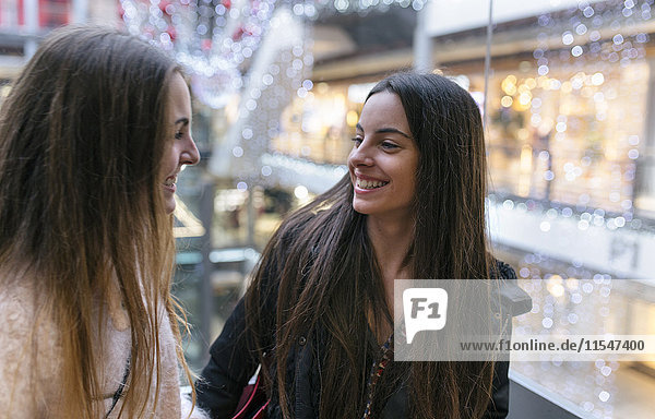 Zwei Freundinnen von Angesicht zu Angesicht in einem Einkaufszentrum