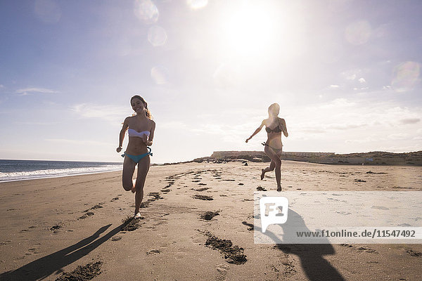 Spanien  Teneriffa  zwei Freundinnen  die am Strand rennen