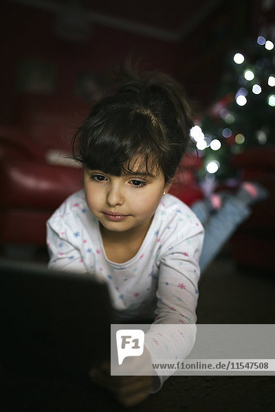 Portrait of little girl using digital tablet at home