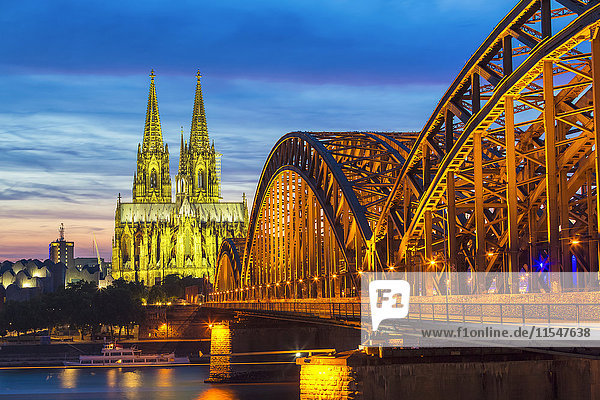 Deutschland  Köln  Blick auf den beleuchteten Kölner Dom mit der Hohenzollernbrücke im Vordergrund