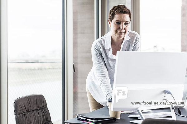 Businesswoman looking at computer monitor in office