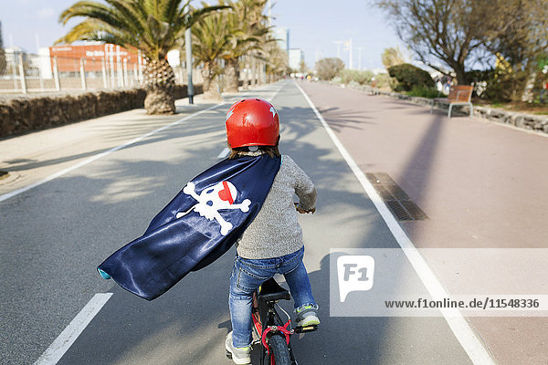 Spanien  Barcelona  Rückansicht des kleinen Jungen mit Piratenumhang auf einer leeren Straße