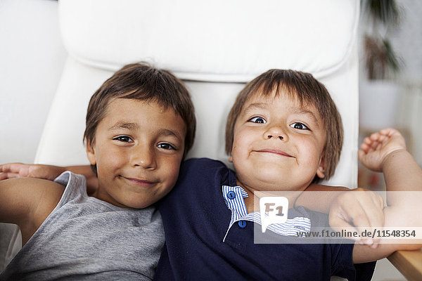 Portrait of two smiling little brothers arm in arm