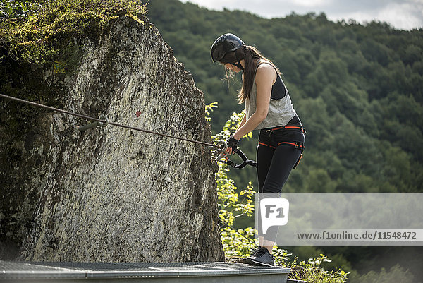 Germany  Westerwald  Hoelderstein  woman climbing on via ferrata