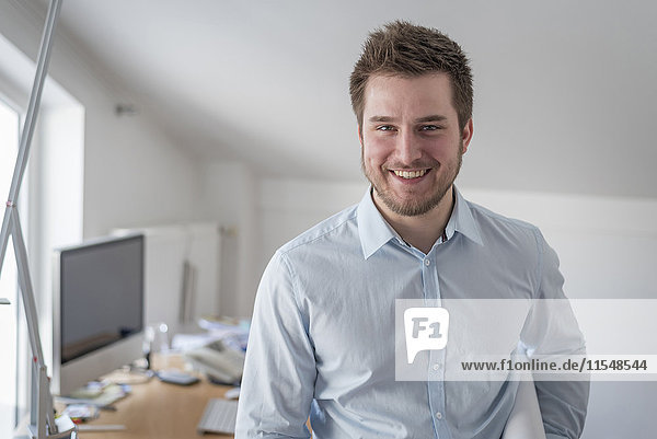 Porträt eines lächelnden jungen Mannes im Amt