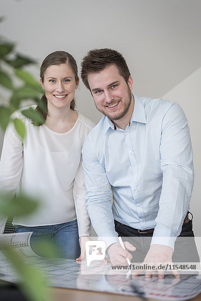 Lächelnder junger Mann und Frau im Büro mit Kalender