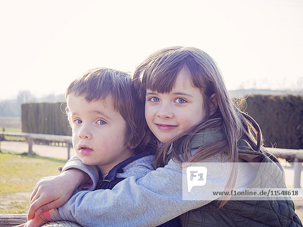 Portrait of smiling girl hugging her little brother