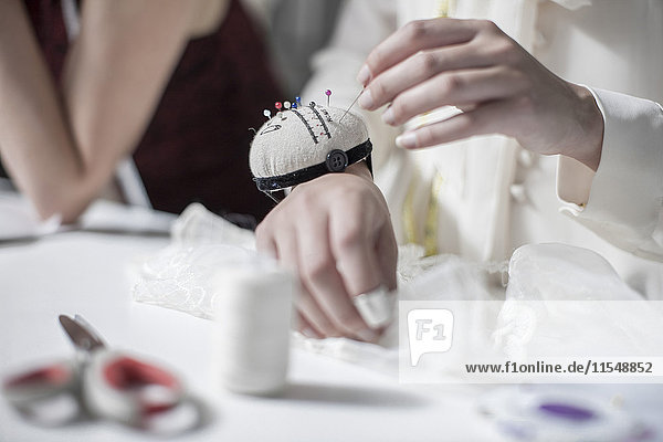 Wedding dress designer working  needlework  pin cushion