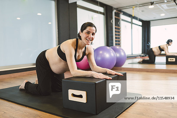 Schwangere Frau bei Pilates-Übungen im Fitnessstudio