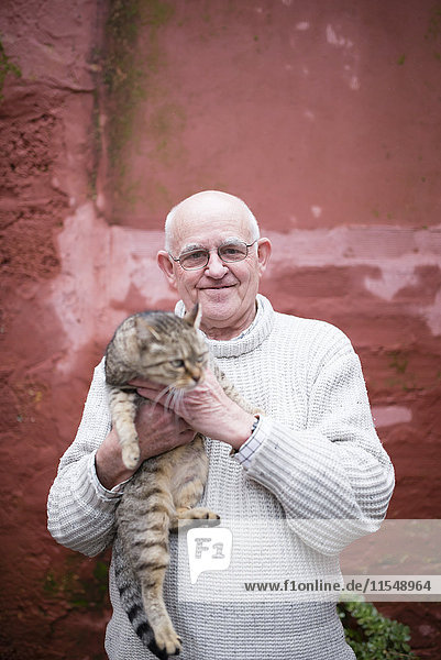 Porträt eines älteren Mannes mit Tabbykatze