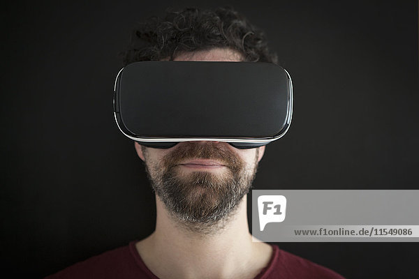 Mann mit Virtual Reality Brille vor schwarzem Hintergrund