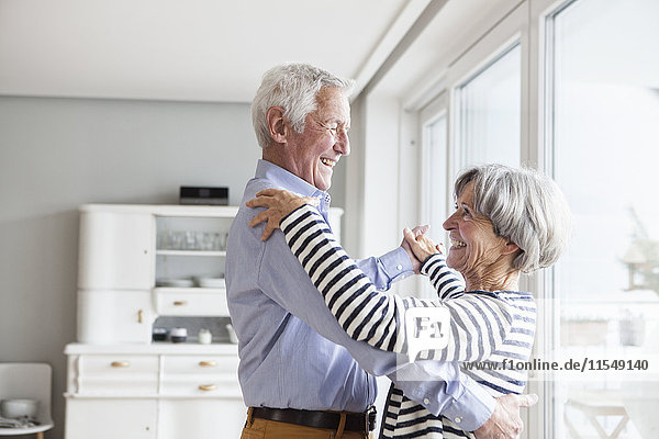 Seniorenpaar tanzt zu Hause zusammen.