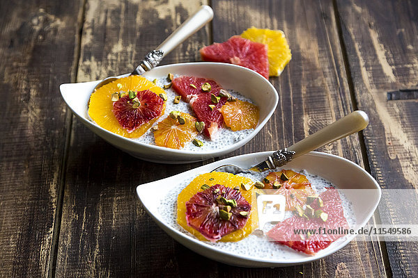 Chia Pudding und Scheiben von Orangenblutorange und Grapefruit  Schalen auf Holz
