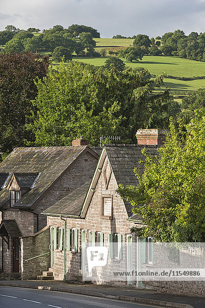 UK  Wales  Hay-on-Wye  Alte Häuser in der Church Street mit Hügeln im Hintergrund