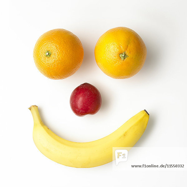 Smiley-Gesicht aus Früchten auf weißem Grund