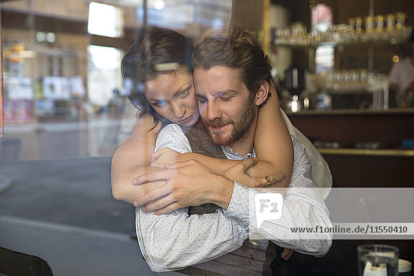 Junges Paar  das sich in einem Cafe umarmt.