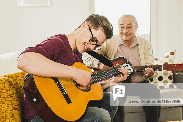Grandfather and grandson playing guitar together