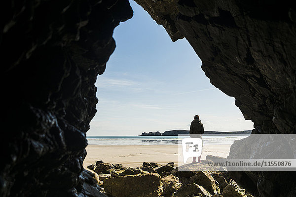 France  Bretagne  Finistere  Crozon peninsula  woman standing on the beach as seen from rock cave