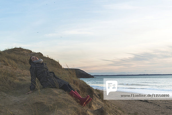 Frankreich  Bretagne  Finistere  Halbinsel Crozon  Frau an der Küste sitzend