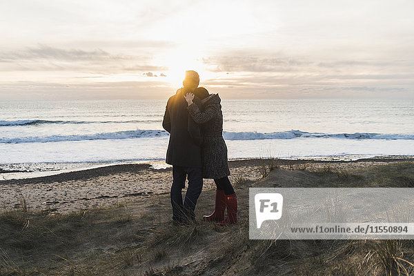 France  Bretagne  Finistere  Crozon peninsula  couple hugging at the coast at sunset