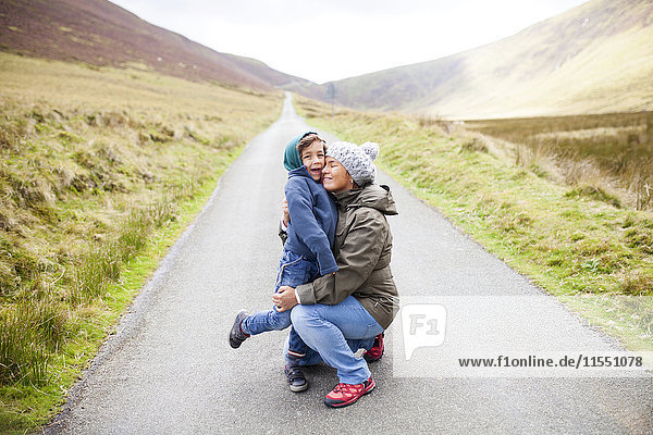 UK  Bala  Mutter und Sohn umarmen sich auf der Straße mitten in den Bergen.