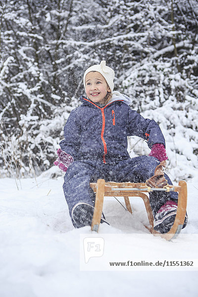 Portrait of girl sledging in the forest