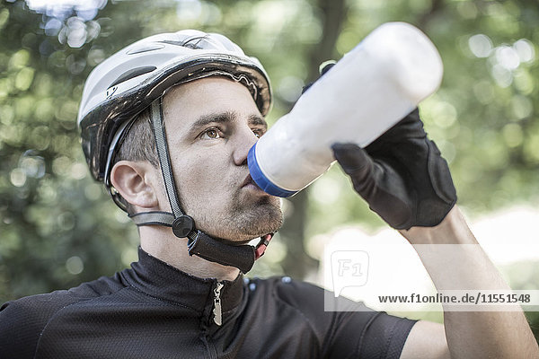 Man in cycling clothes drinking water