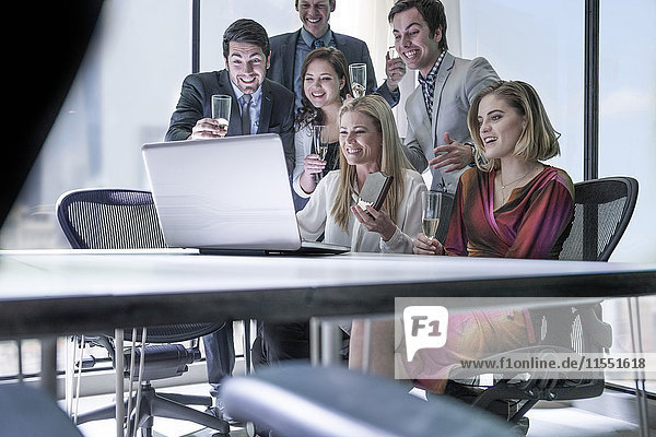 Geschäftsleute feiern Erfolg im Büro  Blick auf Laptop