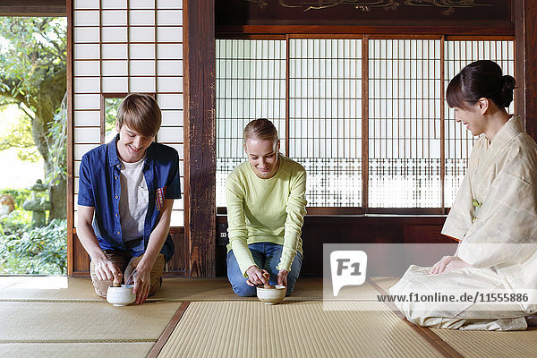 Caucasian couple enjoying tea ceremony at traditional Japanese house
