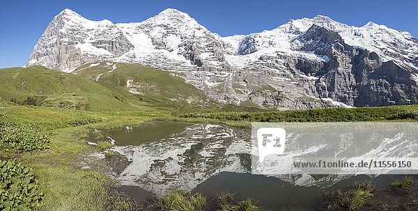 Panorama von verschneiten Gipfeln  die sich im Alpensee spiegeln  Wengernalp  Wengen  Berner Oberland  Kanton Bern  Schweiz  Europa