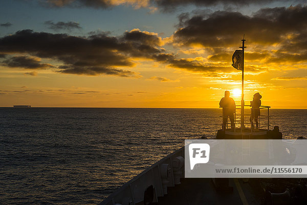 Tourists standing on the bow of a cruise ship watching the sunset  South Orkney Islands  Antarctica  Polar Regions
