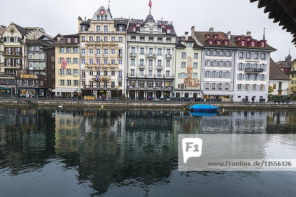 The typical buildings of the old medieval town are reflected in River Reuss  Lucerne  Switzerland  Europe
