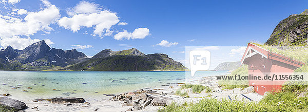 Panorama of the turquoise sea surrounded by peaks and typical house of fishermen  Strandveien  Lofoten Islands  Norway  Scandinavia  Europe