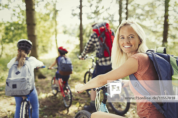 Portrait lächelnde Mutter Mountainbike mit Familie im Wald