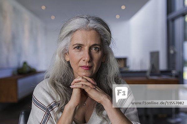 Porträt einer selbstbewussten  ernsten reifen Frau mit langem  grauem Haar