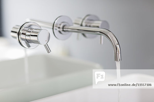 Close up modern  minimalist bath faucet with running water