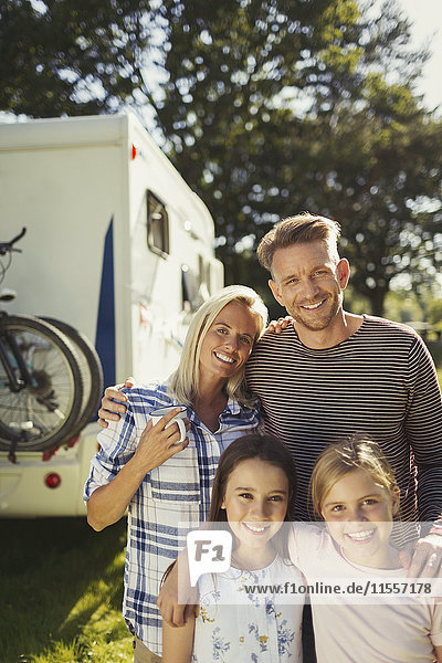 Portrait lächelnd liebevolle Familie außerhalb des sonnigen Wohnmobils