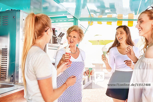Senior Unternehmerin serviert Eiscreme für junge Frauen im Speisewagen