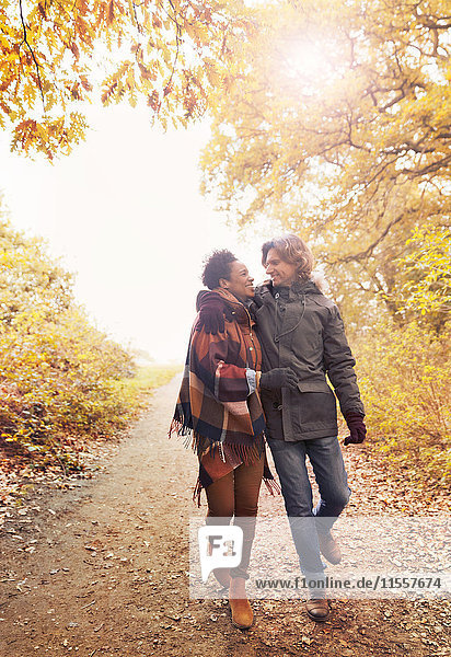 Affectionate couple walking on path in autumn park
