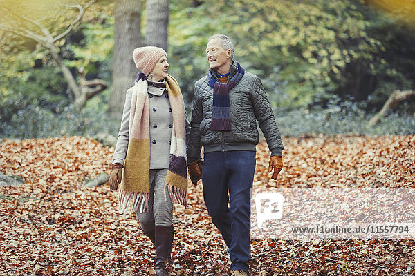 Seniorenpaar beim Wandern im Herbstlaub im Park