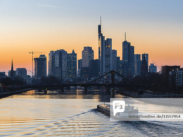 Deutschland  Frankfurt  Blick auf die Skyline mit Flößerbrücke und Main im Vordergrund bei Morgendämmerung