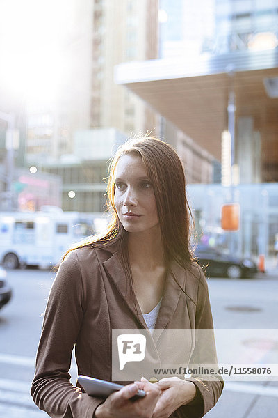 USA  New York  Manhattan  Portrait einer ernsthaften jungen Geschäftsfrau mit Tablette