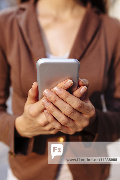 Hands of businesswoman holding cell phone  close-up