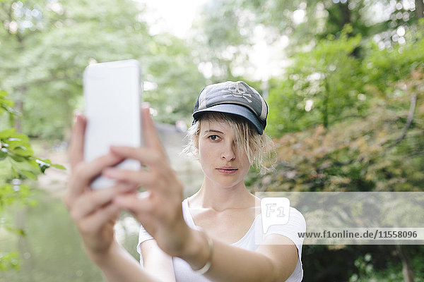 Junge Frau mit einem Selfie im Park