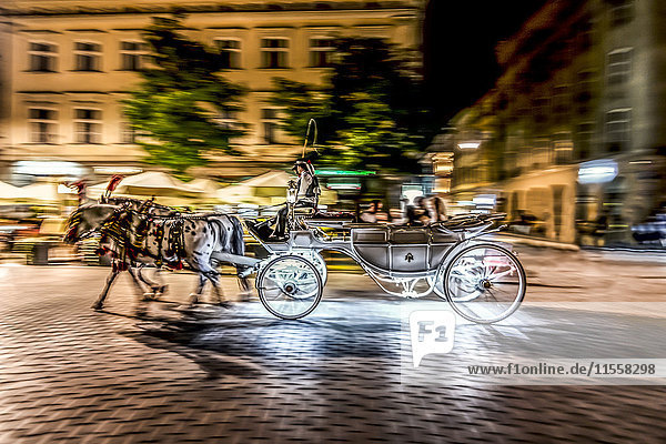 Polen  Krakau  Altstadt  Hauptplatz  nachts fahrende Kutsche