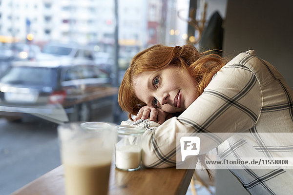 Tagträumende junge Frau im Café